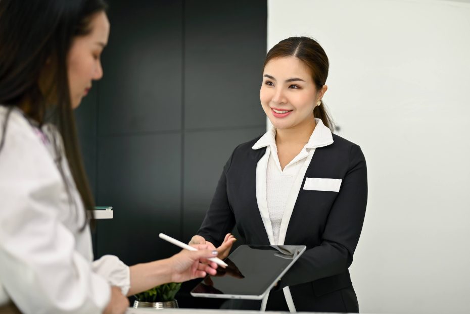 Receptionist helping a woman use an ipad
